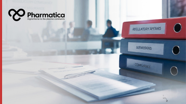 Pharmatica image of a modern pharmaceutical regulatory affairs workspace representing documentation, compliance, and submission processes essential for FDA drug approval. The scene shows three binders labeled &ldquo;Regulatory Affairs,&rdquo; &ldquo;Submissions,&rdquo; and &ldquo;Compliance&rdquo; on a clean office desk with documents and a pen in the foreground, while a blurred meeting of professionals is visible through a glass wall in the background. The composition conveys administrative precision and regulatory science underpinning.