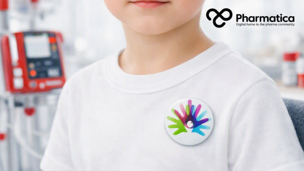 Pharmatica close-up image of a young child wearing a white T-shirt with a Rare Disease Day badge, seated in a bright clinical home environment with red medical devices in the background, representing rare disease care, patient independence, and humanitarian medical technology.