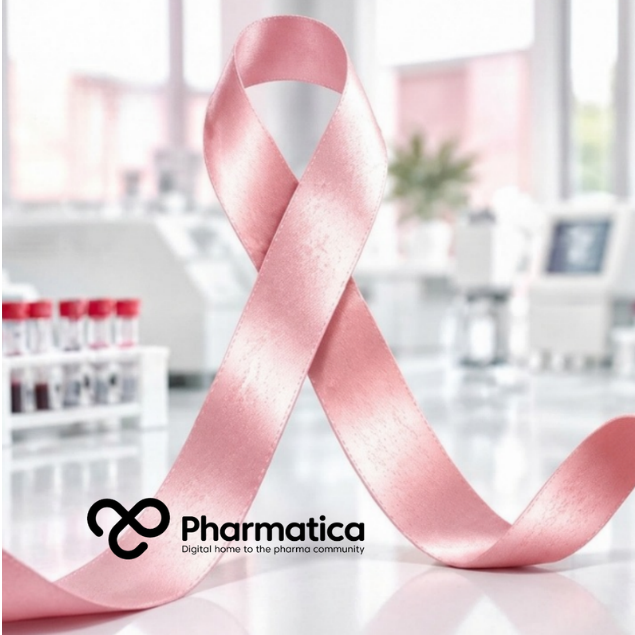 Pharmatica image of a gloved hand holding a blood sample tube in a bright laboratory with red and pink tones and the Pink Breast Cancer Awareness ribbon.