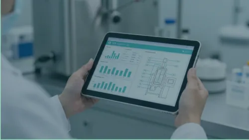 A scientist uses a digital monitor to track the dashboard of a digital twin during pharma manufacturing.